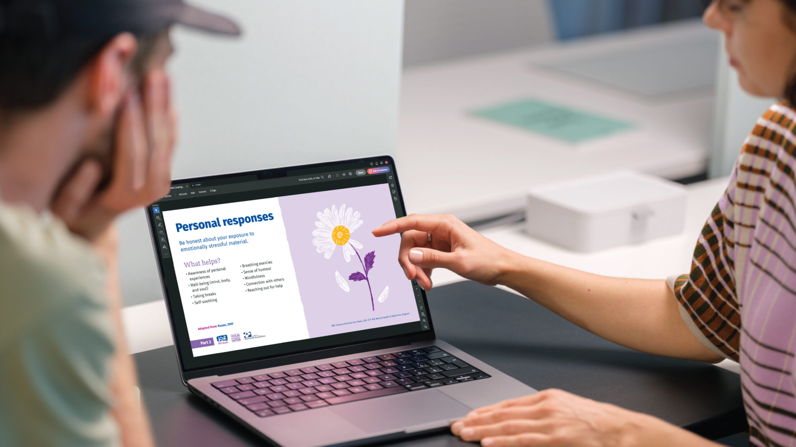 Two adults reviewing presentation on laptop.