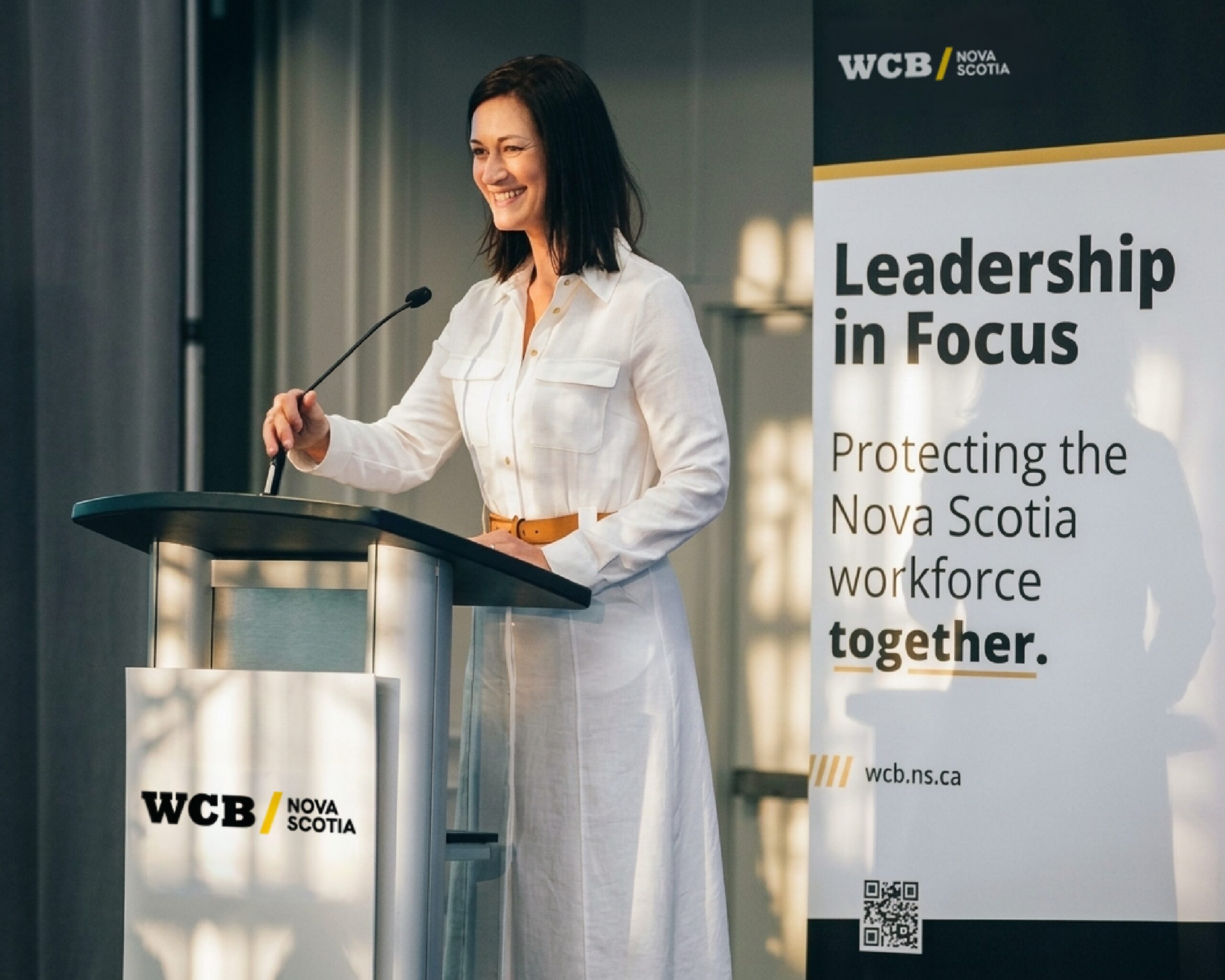 WCB CEO, Karen Adams, standing at podium.